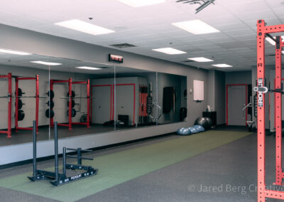 A gym with mirrors and people in it