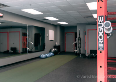 A gym with mirrors and a green floor