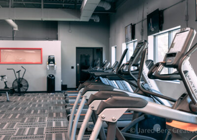 A gym with many machines and a window