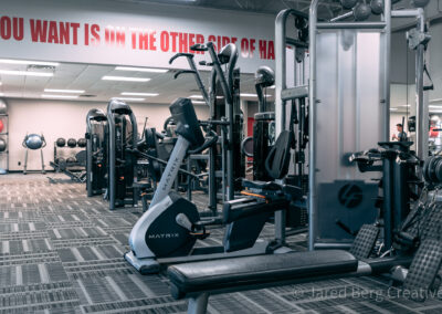 A gym with many different machines and benches.