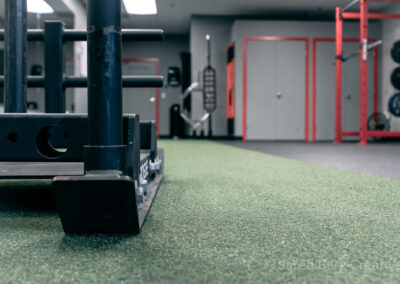 A gym with green carpet and red door.