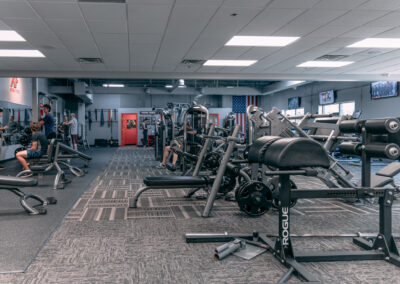 A gym with many machines and people in it